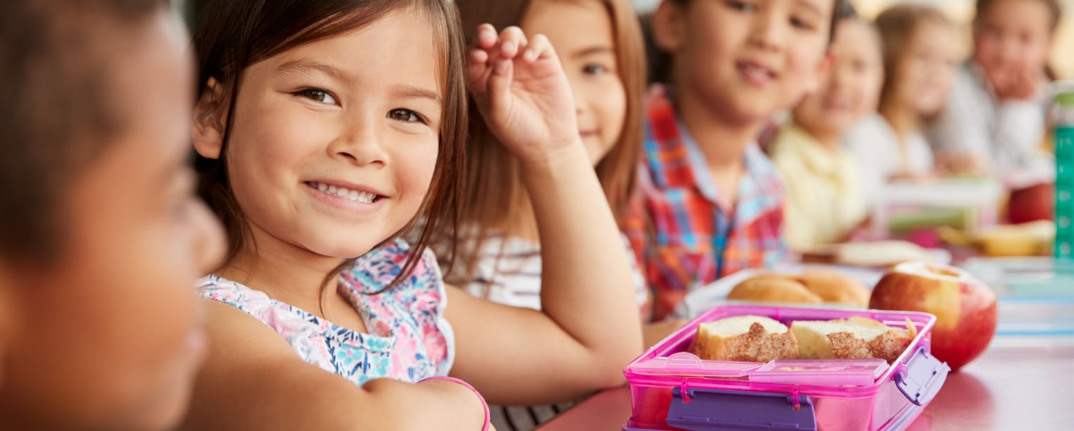 Happy young girl eating lunch