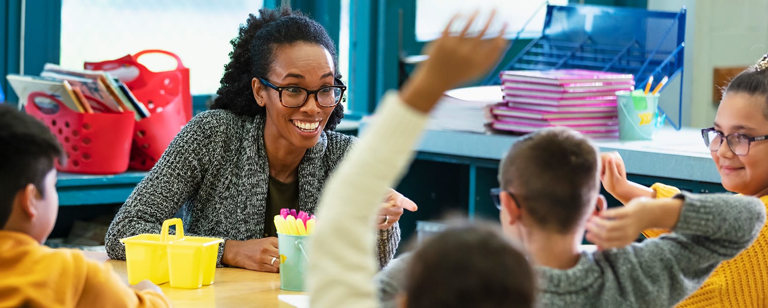 Teacher with kids raising hands